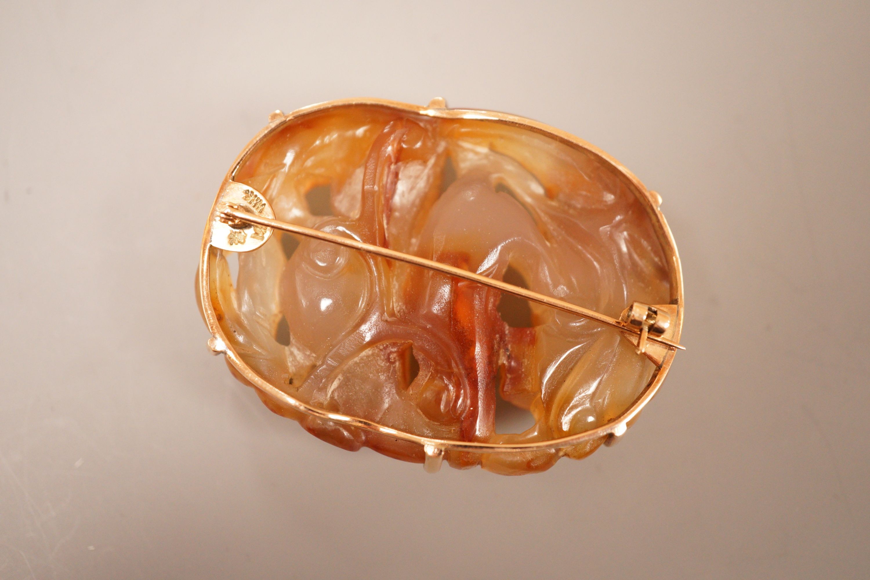 A Chinese carved agate plaque, Qing dynasty, later mounted as a brooch, 5.5cm long
